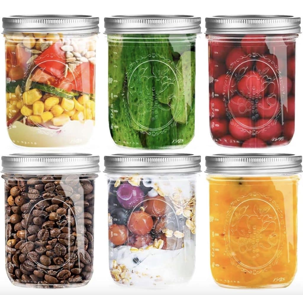 Six glass jars filled with various items: mixed vegetables, sliced cucumbers, cranberries, coffee beans, yogurt with fruit and granola, and an orange mocktail liquid—perfect for exploring easy summer recipes—all sealed with metal lids and arranged in two rows.